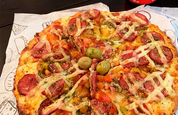 Pizza 4 Fatias Qualquer Sabor + Refri Lata para Consumo Estilo Americano, de R$29,90 por R$19,90. Válido para Todos os Dias (Exceto Terça)!