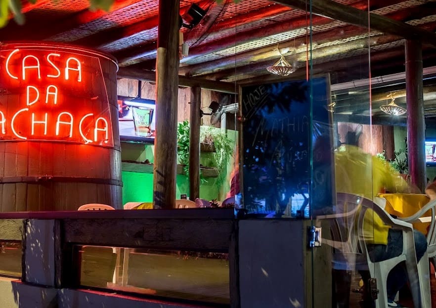 fachada da casa da cachaça com tonel de cachaça escrito em neon vermelho