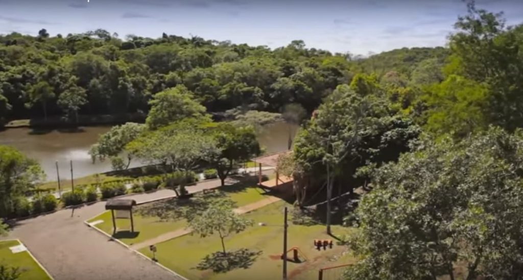 Vista panorâmica de um parque natural com vegetação exuberante e um lago ao fundo. Espaço ideal para lazer e relaxamento em meio à natureza. Com o intuito de economizar com passeios gratuitos
